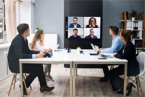 Team in a large meeting room on a video conference call