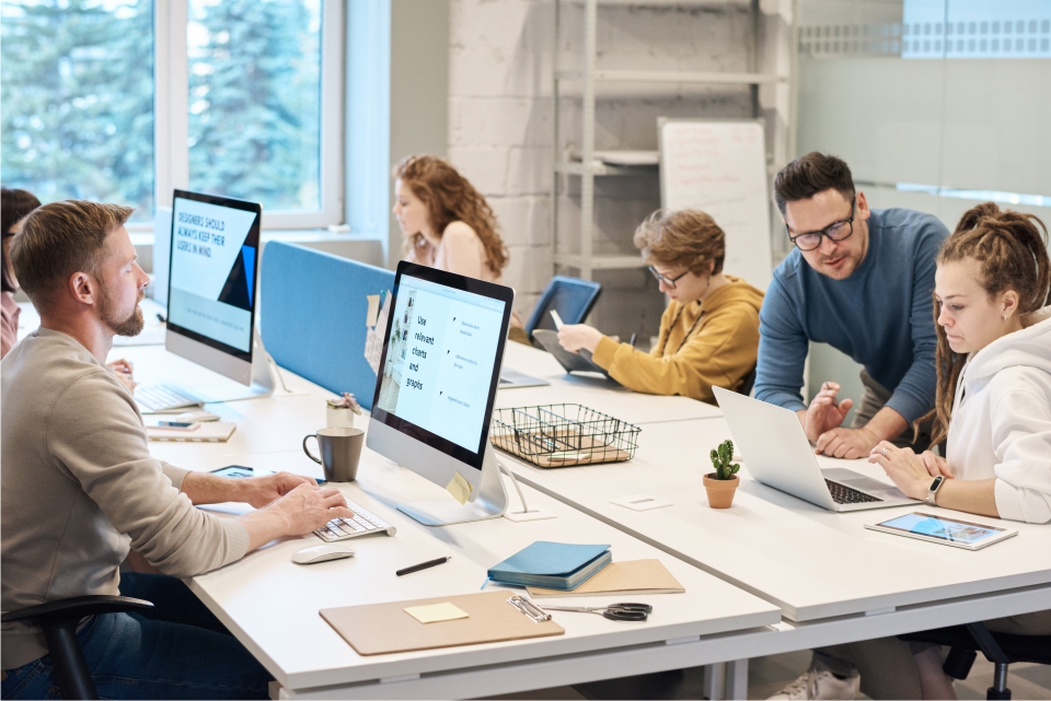 Office workers in a busy modern office with audio visual technology