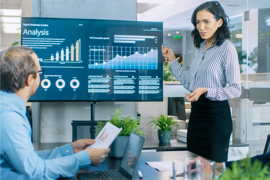 Woman presenting in from of a digital screen