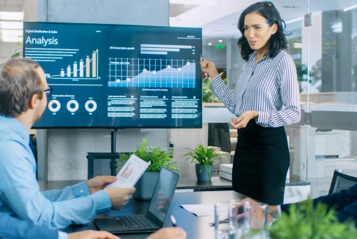 Woman presenting information on screen to colleagues