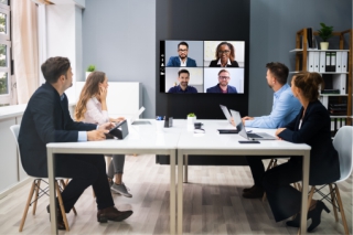 Colleagues video conferencing in meeting room
