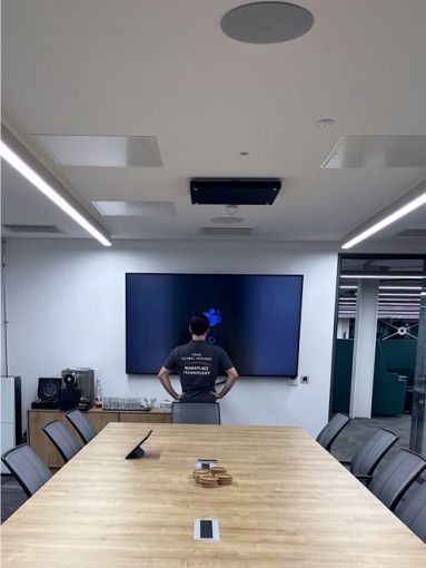 IT technician setting up Microsoft Teams in boardroom room.