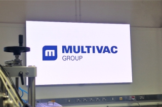 6 digital LED screen in multivac innovation centre Large all-in-one LED screen with a bright display showing the Multivac logo.