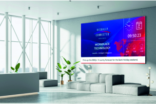 Multipurpose meeting space with a large digital screen showing digital signage.